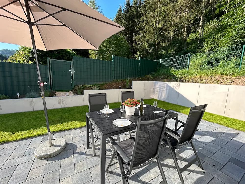 Terrasse mit Sonnenschirm im Garten Ferienhaus Leimbach N°4